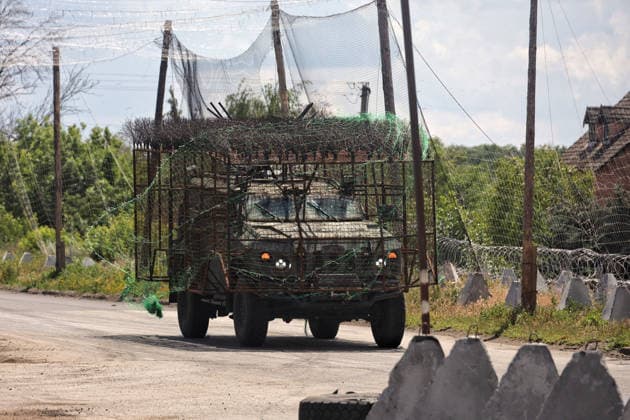 Ukraine-Krieg, Militärfahrzeuge passieren Straße mit Anti-Drohnen-Netzen in der Region Donezk