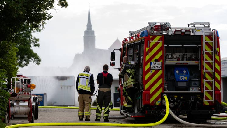 Sachsen, Bautzen, Einsatzkräfte der Feuerwehr kühlen den brennenden Batteriespeicher am Bautzener Schliebenparkplatz