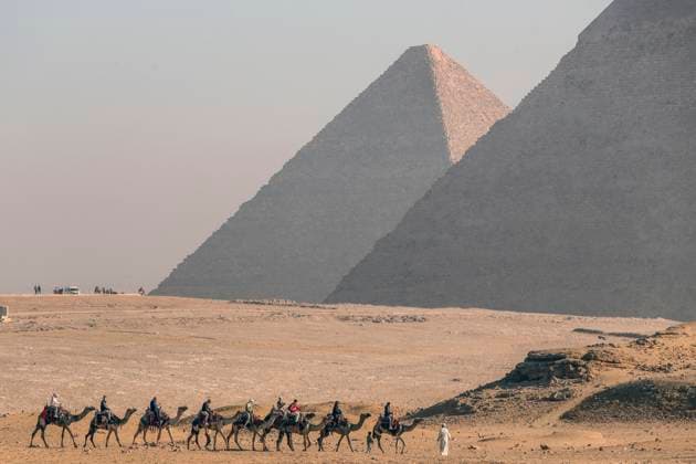 Ägypten, Touristen auf Kamelen vor den Pyramiden von Gizeh