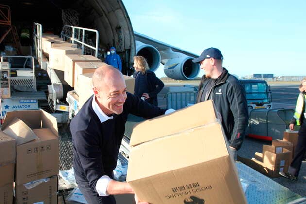 Coronavirus in Dänemark, Gesundheitsminister Magnus Heunicke hilft beim entladen eines Flugzeuges