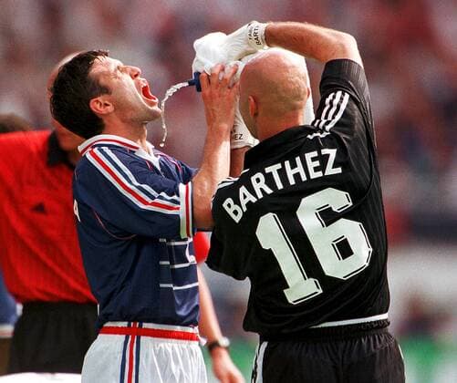 Nationaltorhüter Fabien Barthez begießt seinen Mannschaftskollegen Vincent Candela (li.) Fußball WM Herren Weltmeisterschaft 1998, Länderspiel, Nationalmannschaft, Nationalteam, Nationaltrikot Gruppe Stade Gerland Lyon Kameradschaft,