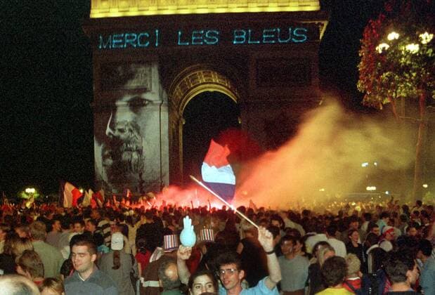 Französische Siegesfeier am Arc de Triomphe mit dem Bild von Zinedine Zidane und der Aufschrift Merci les Bleus Fußball WM Herren Weltmeisterschaft 1998, Länderspiel, Nationalmannschaft, Nationalteam, Nationaltrikot Totale Paris Begeisterung, Freude,