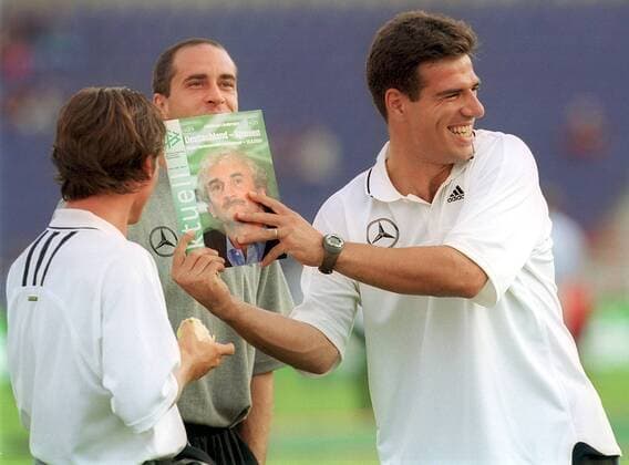 V. li.: Dariusz Wosz, Stefan Beinlich und Paulo Rink (alle Deutschland) erheitert das Konterfei ihres Trainers auf einer DFB-Broschüre Fußball Länderspiel Herren Freundschaftsspiel 2000, Nationalmannschaft, Nationalteam Gruppe Niedersachsenstadion Hannover Komik