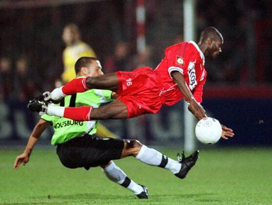 Moussa Latoundji (Cottbus, vorn) liegt waagerecht in der Luft, dahinter T. Maric (Wolfsburg) Fußball 1. BL Herren Saison 2000 2001, FC Energie Cottbus - VfL Wolfsburg 0:0 Gruppe Stadion der Freundschaft Cottbus Dynamik, Höhe