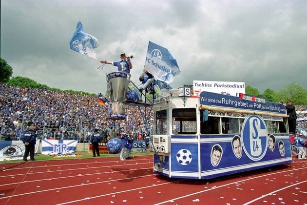Schalker Fans halten Einzug ins Stadion Fußball 1. BL Herren Saison 2000 2001, FC Schalke 04, Logo, Emblem, Wappen, Vereinswappen, Fahne, Fahnen, Flagge, Flaggen Totale Parkstadion, Rang, Ränge, Zuschauer, Publikum Gelsenkirchen, Tribüne, Tribünen, voll, Fanflagge