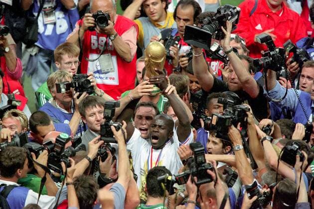 Weltmeister Lilian Thuram (vorn) und Alain Boghossian (beide Frankreich) präsentieren den Fotografenmassen den Pokal Fußball WM Herren Weltmeisterschaft 1998, Länderspiel, Nationalmannschaft, Nationalteam, Endspiel Totale Stade de France Paris, Saint Denis Glück, Masse, Freude, Begeisterung,