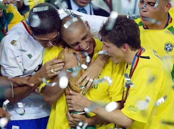 Roberto Carlos (Mitte), Edmilson (li.) und Juninho Paulista (alle Brasilien) umarmen die Trophäe Fußball WM Herren Weltmeisterschaft 2002, Länderspiel, Finale, Endspiel, Nationalmannschaft, Nationalteam, Weltmeister Gruppe International Stadium Yokohama Glück, Harmonie Freude, Begeisterung,