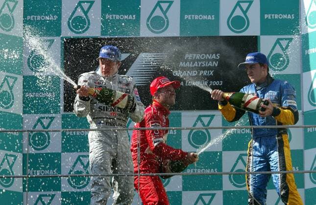 V. li.: Kimi Räikkönen (Finnland McLaren-Mercedes), Rubens Barrichello (Brasilien Ferrari) und Fernando Alonso (Spanien Renault) bei der traditionellen Sektdusche Motorsport Grand Prix Herren Großer Preis von Malaysia 2003, Formel 1 Weltmeisterschaft, F1, F, GP, WM, Vdig Gruppe Sepang