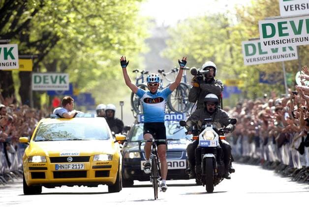 Jan Ullrich (Deutschland Coast) - Siegesjubel bei der Zieldurchfahrt, dahinter ein Kameramotorrad des WDR und der Wagen der Rennleitung Radsport Herren 88. Rund um Köln 2003, Straßenradsport, Rad, Straße Totale Freude, Begeisterung,