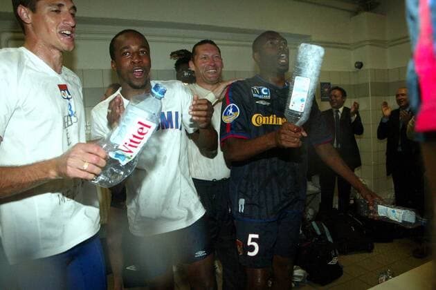 Lautstarke Meisterfeier in der Kabine von Lyon v.li.: Edmilson, Sidney Govou, Sportkoordinator Guy Genet und Claudio Cacapa besingen die Titelverteidigung Fußball Herren Ligue Une 2002 2003, 1. Französische Liga, Montpellier - Olympique Lyonnais 1:1, OL, Vdig Gruppe Montpellier, Kabinenfeier Freude, Begeisterung,  
