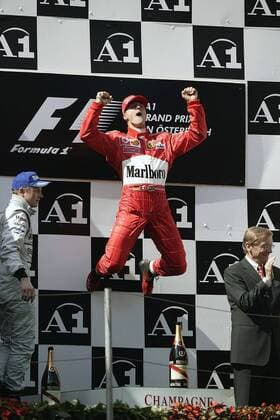 Michael Schumacher (Deutschland Ferrari, Mitte ) feiert mit einem Jubelsprung seinen Sieg, daneben: Bundeskanzler Dr. Wolfgang Schüssel (ÖVP Österreich, re.) und Kimi Räikkönen (Finnland McLaren-Mercedes) Motorsport Grand Prix Herren Großer Preis von Österreich 2003, Formel 1 Weltmeisterschaft, F1, F, GP, WM, Vdig Gruppe A1- Ring Zeltweg-Spielberg Höhe, Freude, Begeisterung,