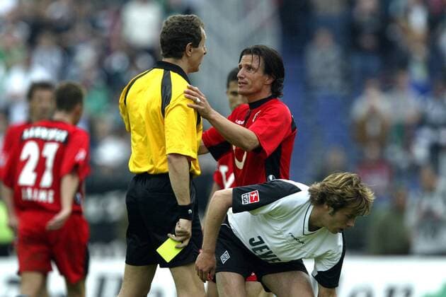 Marc van Hintum (2.v.re, Hannover) versucht Schiedsrichter Hellmut Krug zu besänftigen, der hat jedoch die gelbe Karte schon bereit, vorn: Korzynietz (Gladbach) Fußball 1. BL Herren Saison 2002 2003, Hannover 96 - Borussia Mönchengladbach 2:2, Vdig Gruppe Hannover