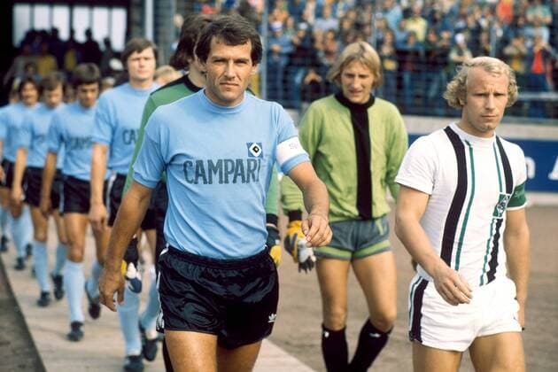Die Mannschaftskapitäne Georg Volkert (li., HSV) und Berti Vogts (Gladbach) führen ihre Teams aufs Spielfeld Fußball 1. BL Herren Saison 1974 1975, Hamburger SV - Borussia Mönchengladbach 1:1 Gruppe Hamburg