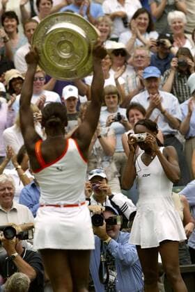 Venus Williams (re., USA) macht ein paar Schnappschüsse ihrer Schwester Serena mit der Wimbledon-Trophäe Tennis Damen All England Championships 2003, Grand Slam, WTA-Tour, Finale, Endspiel Gruppe Wimbledon London Harmonie, Freude, Kameradschaft,