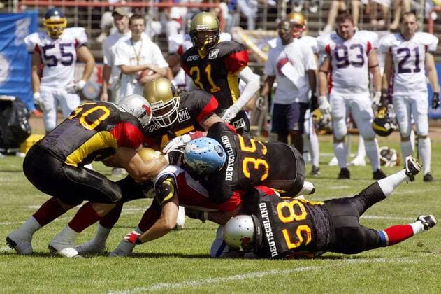 Wide ReceiverJulien Granier (Frankreich) wird gestoppt , v. re.: Linebacker Martin Zimmermann (58), Linebacker John van Look (35), Defensive Back Toko Pfeiffenberger (45) und Linebacker Marcus Bleker (alle Deutschland) American Football WM Herren Weltmeisterschaft 2003, Spiel um Platz 3, dritten, Deutschland - Frankreich 36:7, Länderspiel Gruppe Hanau Kampf,