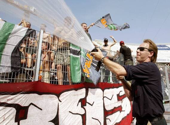Die Hannoveraner Fans können sich bei tropischen Temperaturen über eine Abkühlung aus dem Feuerwehrschlauch freuen Fußball 1. BL Herren Saison 2003 2004, Hannover 96 - FC Bayern München 3:3, Vdig Gruppe Hannover