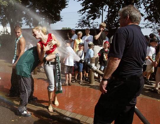 Willkommene Abkühlung für die Bremer Fans, die das Wasserbad in der sommerlichen Hitze sichtlich genießen Fußball 1. BL Herren Saison 2003 2004, SV Werder Bremen Gruppe weiblich, weibliche Bremen