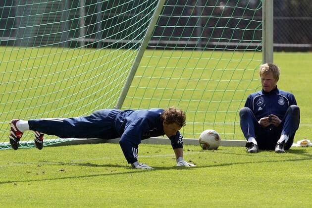 Torwart Oliver Kahn, lässig am Torpfosten sitzend, sieht zu wie sich sein Kollege Jens Lehmann (beide Deutschland) bei den Liegestützen verausgabt Fußball Herren Nationalmannschaftstraining 2003, Nationalmannschaft, Nationalteam, Training, Gruppe Ruit bei Stuttgart