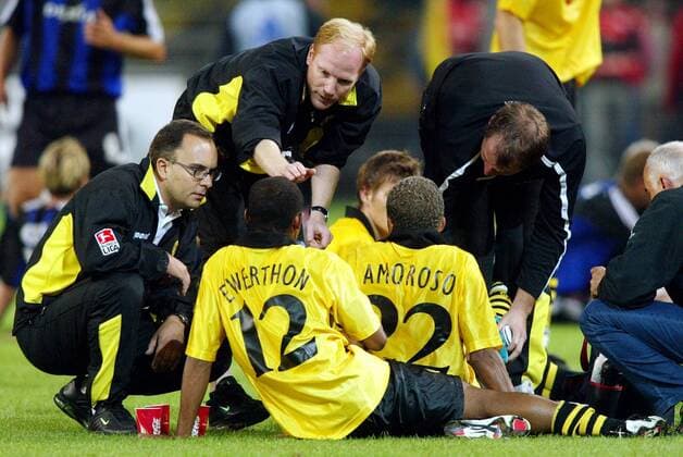 Trainer Matthias Sammer gibt Ewerthon (2.v.li.) und Amoroso (2.v.re.) letzte Anweisungen, Mannschaftsarzt Dr. Marcus Braun (li.) und Physiotherapeut Frank (re., alle BVB) kümmern sich um das Befinden der Spieler Fußball EC 1 Herren Champions League Qualifikation 2003 2004, Borussia Dortmund, Gruppe Dortmund