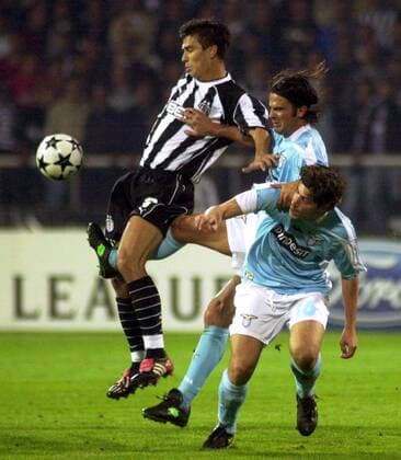 Fernando Couto (Mitte, Lazio) trifft den Ball durch die Beine von Daniel Pancu (li., Besiktas) und muss sich dabei an Giuliano Giannichedda (Lazio) festhalten Fußball EC 1 Herren Champions League 2003 2004, Besiktas Istanbul - Lazio Rom 0:2, Gruppe Istanbul Dynamik, Kampf,