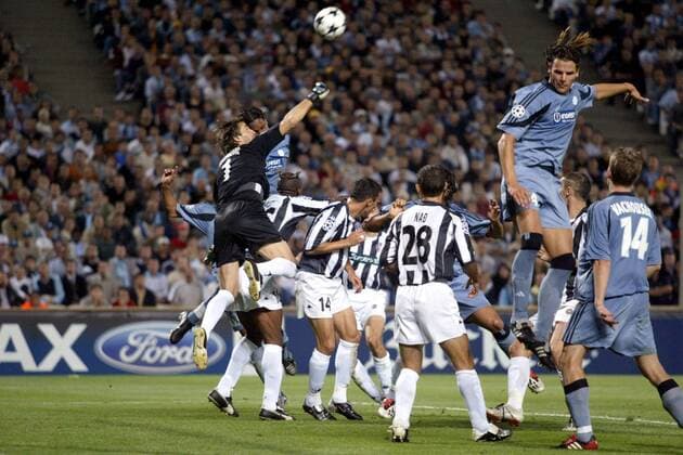 Torraumszene: Torwart Radovan Radakovic (Belgrad, li.) faustet den Ball aus der Gefahrenzone; re. Daniel van Buyten (Marseille Fußball EC 1 Herren Champions League 2003 2004, Olympique Marseille - Partizan Belgrad 3:0, OM Gruppe Marseille Abwehr, Dynamik, Höhe  