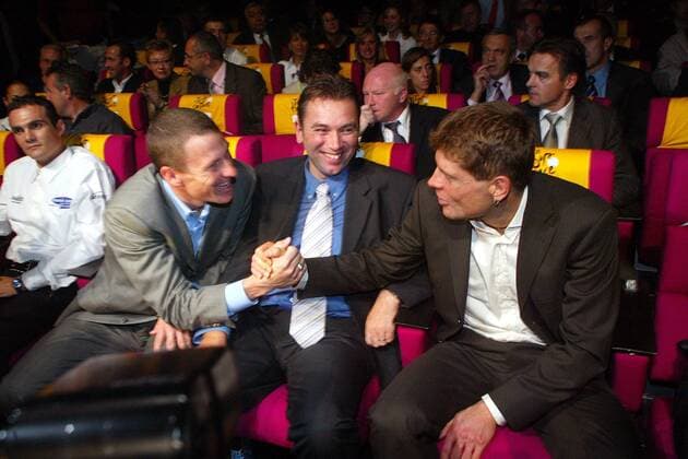 Jan Ullrich (li., Deutschland T Mobile) und Lance Armstrong (USA US Postal Service), schütteln sich bei der Präsentation der Tour de France 2004 die Hände, dazwischen freut sich der Sportliche Leiter Johan Bruyneel (Belgien US Postal) auf das Duell Radsport Herren Tour de France Präsentation 2003, Radrennen, Vorstellung, Pressetermin, Vorschau Gruppe Paris  