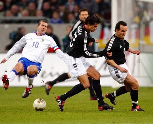Während Zinedine Zidane (Frankreich, li.) abhebt laufen Michael Ballack (Mitte) und Jens Jeremies (beide Deutschland) am Ball vorbei Fußball Länderspiel Herren Freundschaftsspiel 2003, Nationalmannschaft, Nationalteam, Nationaltrikot, Länderspiel Gruppe Test, Testspiel Gelsenkirchen Dynamik,