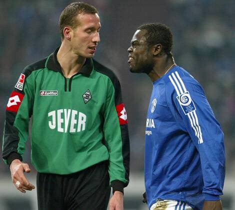 Jeff Strasser (Gladbach, li.) ignoriert den Wutausbruch von Gerald Asamoah (Schalke) Fußball 1. BL Herren Saison 2003 2004, FC Schalke 04 - Borussia Mönchengladbach 2:1, Vdig Gruppe Aggressionen, aggressiv, böse, schnauben Gelsenkirchen Kampf Spannung, Wut,