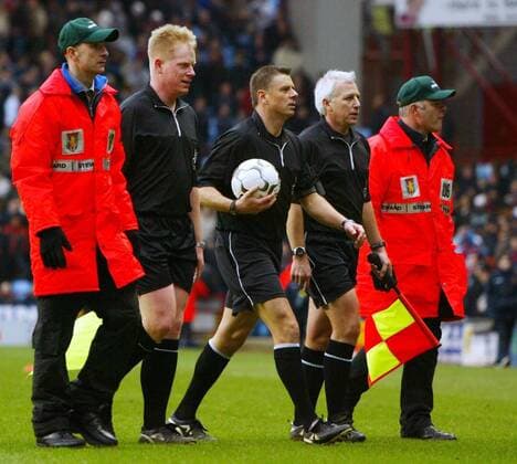 Das Schiedsrichtergespann um Schiedsrichter Mark Halsey (Mitte) verlässt nach einer umstrittenen Entscheidung von Ordnern begleitet das Spielfeld Fußball Herren English Premier League 2003 2004, 1. Englische Liga, Aston Villa Gruppe Birmingham