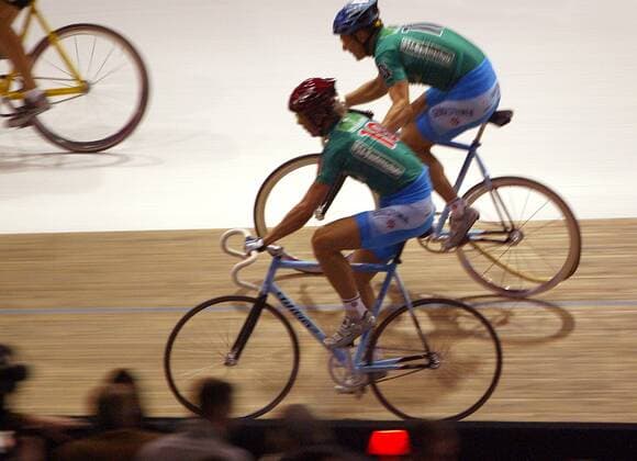 Olaf Pollack (hinten) fliegt beim Wechsel der Reifen vom Hinterrad, Danilo Hondo (beide Deutschland) hilft seinem Partner Radsport Herren 93. Berliner 6-Tage-Rennen 2004, Sechstagerennen, Sechstage, Sechs, Sixdays, six days, Vdig Gruppe Berlin
