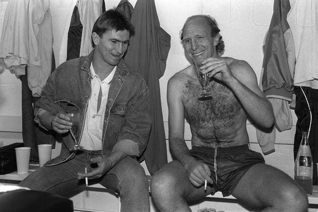 Fußball, FC Bayern München, Deutscher Meister 1987 Kabinenfeier der Bayern - Klaus Augenthaler (li.) und Dieter Hoeneß (beide Bayern) gönnen sich nach dem vorzeitigen Gewinn der Deutschen Meisterschaft ein Glas Sekt und eine Zigarette Fußball 1. BL Herren Saison 1986 1987, FC Bayern München Gruppe München Freude,