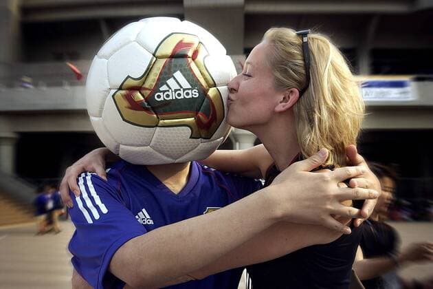 Dieser Fan hat nur Fußball im Kopf - doch das kann sich auch lohnen, hier bekommt er einen dicken Schmatzer von einer Frau Fußball WM Herren Weltmeisterschaft 2002, Länderspiel, Gruppenspiel, Gruppe H, Nationalmannschaft, Nationalteam Gruppe Saitama Freude,
