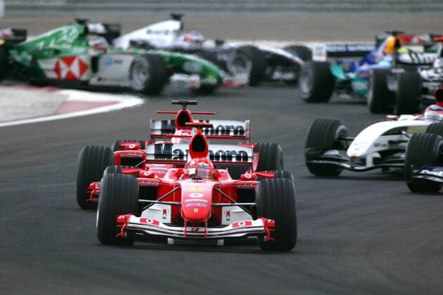 Start GP Bahrain 2004: Michael Schumacher (Deutschland Ferrari) führt das Starterfeld durch die erste Kurvenkombination Motorsport Grand Prix Herren Großer Preis von Bahrain 2004, Formel 1 Weltmeisterschaft, F1, F, GP, WM Gruppe Bahrain Racing Circuit Manama