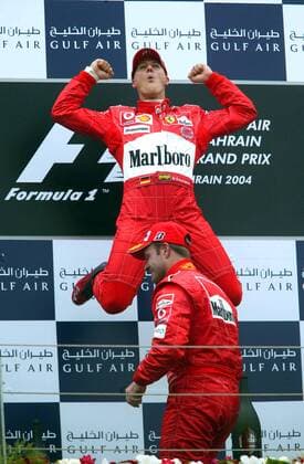 Michael Schumacher (Deutschland) überflügelt nicht nur bei der Siegerehrung seinen Teamkollegen Rubens Barrichello (Brasilien, beide Ferrari) Motorsport Grand Prix Herren Großer Preis von Bahrain 2004, Formel 1 Weltmeisterschaft, F1, F, GP, WM, Vdig Gruppe Bahrain Racing Circuit Manama Freude, Begeisterung,