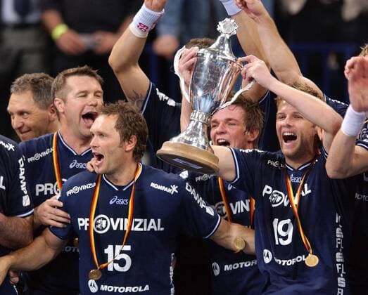 Die Titelverteidiger v. li.: Co-Trainer Bogdan Wenta, Lars Christiansen, Robert Runge und Sören Stryger bejubeln den Pokalsieg Handball 1. BL Herren DHB-Pokal 2003 2004, Pokalspiel, Top Four Turnier, Pokalfinale, Finale, Endspiel, Pokalendspiel Gruppe Gold, Goldmedaille, Goldmedaillen, Hamburg Begeisterung, Freude,