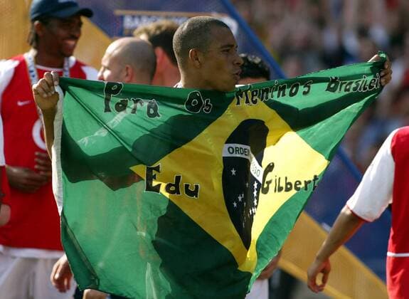 Gilberto Silva (Arsenal) feiert mit einer brasilianischen Nationalfahne den Gewinn der Englischen Meisterschaft Fußball Herren English Premier League 2003 2004, 1. Englische Liga, Arsenal FC London, Meisterfeier, Vdig Gruppe London Freude