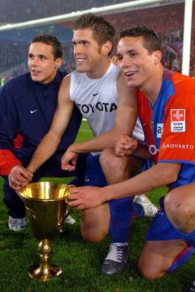 Philipp (re.) und David Degen (li.) haben sich mit Benjamin Huggel (alle Basel) um den Meisterpokal versammelt Fußball Herren Super League 2003 2004, Nationalliga A, NLA, 1. Schweizer Liga, FC Basel, Vdig Gruppe Basel, Geschwister Freude,