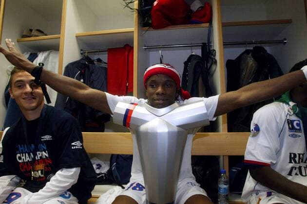 Pegguy Luyindula (re.) setzt seinen Kopf auf die Meistertrophäe, daneben Yohan Gomez (beide Lyon) Fußball Herren Ligue Une 2003 2004, 1. Französische Liga, Olympique Lyonnais, OL Gruppe Aufmacher Lyon Freude, Komik,  