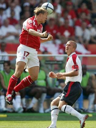 Christoph Spycher (li., Schweiz) - Kopfball, David Beckham (England) schaut zu Fußball EM Herren Euro 2004, Europameisterschaft, Länderspiel, Nationalmannschaft, Nationalteam, Gruppe B, Vdig Gruppe Coimbra Dynamik,