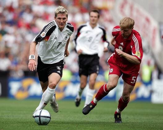 Bastian Schweinsteiger (Deutschland, li.) im Laufduell mit Juris Laizans (Lettland) Fußball EM Herren Euro 2004, Europameisterschaft, Länderspiel, Nationalmannschaft, Nationalteam, Gruppe D Gruppe Porto Dynamik,