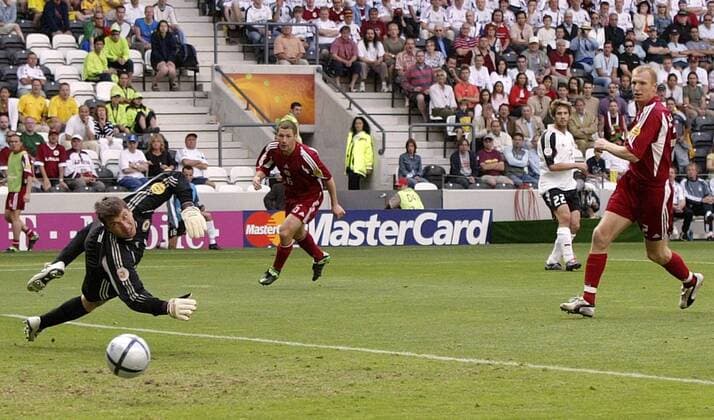 Torsten Frings (Deutschland, hi.) verfehlt gegen Torwart Aleksandrs Kolinko, Igors Stepanovs (re.) und Olegs Blagonadezdins (alle Lettland) nur knapp das Tor Fußball EM Herren Euro 2004, Europameisterschaft, Länderspiel, Nationalmannschaft, Nationalteam, Gruppe D, Totale Porto Dynamik,