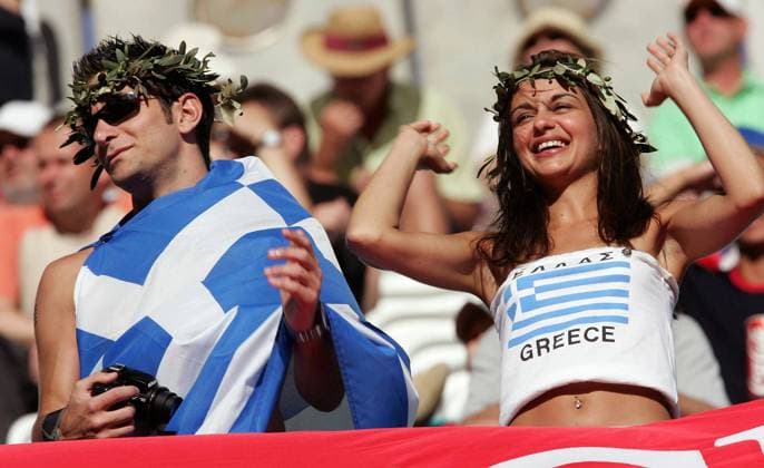 Ein griechisches Fanpärchen mit zum Kranz gebogenen Ölzweigen Fußball EM Herren Euro 2004, Europameisterschaft, Länderspiel, Nationalmannschaft, Nationalteam, Gruppe A Gruppe Nationalfahne, Nationalfahnen, Ölzweig, Ölzweige Faro-Loule, Ölzweigkranz