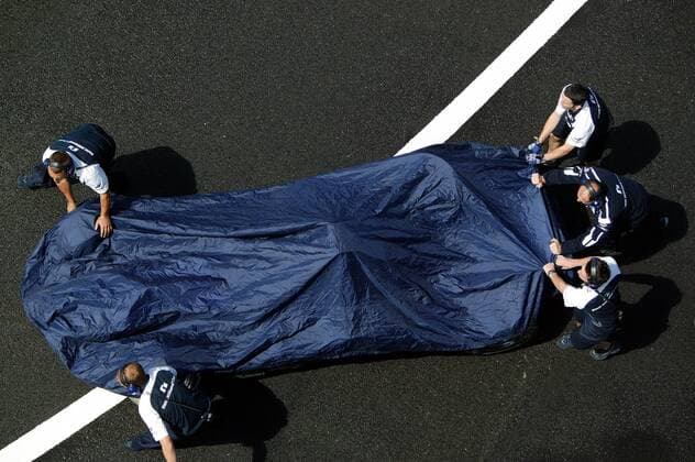 Geheimniskrämerei um den überarbeiteten BMW-Williams FW 26 von Juan Pablo Montoya (Kolumbien); Mechaniker schieben den Boliden durch die Boxengasse Motorsport Grand Prix Herren Großer Preis von Frankreich 2004, Formel 1 Weltmeisterschaft, F1, F, GP, WM, Freies Training Gruppe Circuit de Nevers Magny-Cours