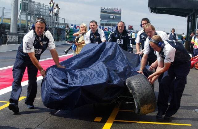 Geheimniskrämerei um den beschädigten BMW-Williams FW 26 von Juan Pablo Montoya (Kolumbien); Mechaniker schieben den Boliden durch die Boxengasse Motorsport Grand Prix Herren Großer Preis von Frankreich 2004, Formel 1 Weltmeisterschaft, F1, F, GP, WM, Freies Training Gruppe Circuit de Nevers Magny-Cours