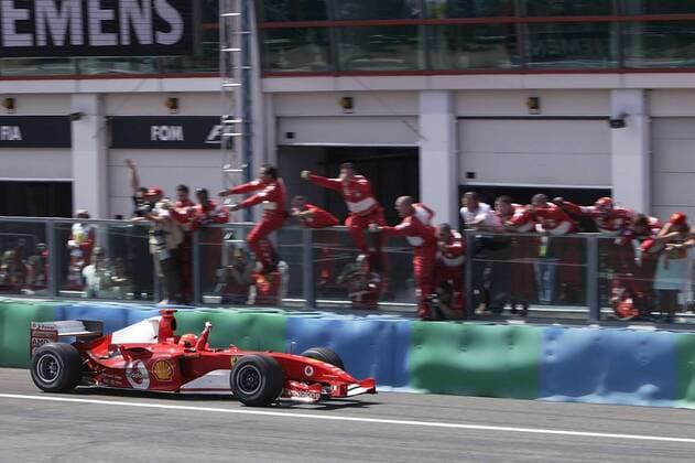 Sieger Michael Schumacher (Deutschland Ferrari) fährt dicht an der Boxenmauer vorbei und lässt sich von seinem Team feiern Motorsport Herren Großer Preis von Frankreich 2004, Formel 1 Weltmeisterschaft, F1, F, GP, WM Totale Magny-Cours Freude, Begeisterung,