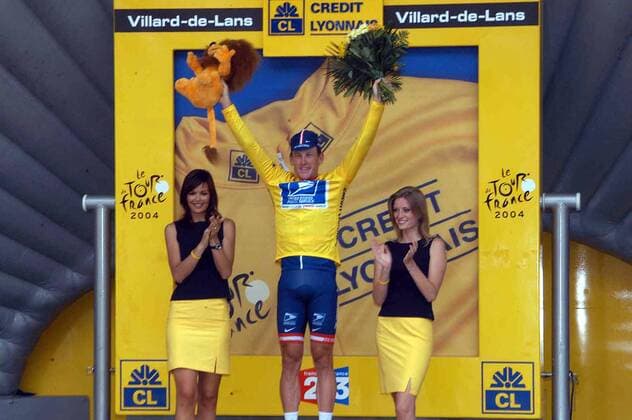 Lance Armstrong (USA US Postal Service) genießt sein gelbes Trikot und den Beifall der Hostessen während der Siegerehrung Radsport Herren Tour de France 2004, Straßenradsport, Straße, Rad, Vdig Gruppe 15. Etappe Valreas - Villard-de-Lans Freude,  
