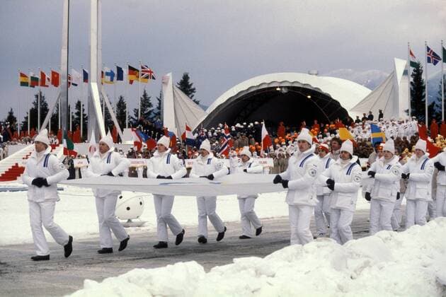 Eröffnungszeremonie der Olympischen Spiele 1980 in Lake Placid - Ehemalige Olympiasieger der USA, darunter Eisschnelläufer Jack Shea, Diskuswerfer Al Oerter und Boxer Floyd Patterson, tragen die Olympiafahne ins Stadion Eisschnellauf OS Winter Herren Olympische Winterspiele 1980, Olympia, Olympiade, Spiele, Eröffnung, Eröffnungsfeier, Feier, Vdia Totale Lake Placid