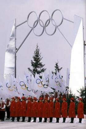 Hostessen in Uniform warten während der Eröffnungszeremonie der Olympischen Spiele 1980 in Lake Placid unter den Olympischen Ringen OS Winter Herren Olympische Winterspiele 1980, Olympia, Olympiade, Spiele, Eröffnung, Eröffnungsfeier, Feier, Vdia Totale Lake Placid