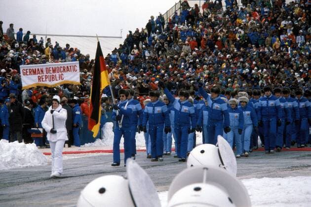 Eröffnungszeremonie der Olympischen Spiele 1980 in Lake Placid - Fahnenträger Jan Hoffmann führt die Delegation der DDR ins Stadion Eiskunstlauf OS Winter Herren Olympische Winterspiele 1980, Olympia, Olympiade, Spiele, Eröffnung, Eröffnungsfeier, Feier, Vdia Totale Einmarsch, einlaufen, auflaufen Lake Placid