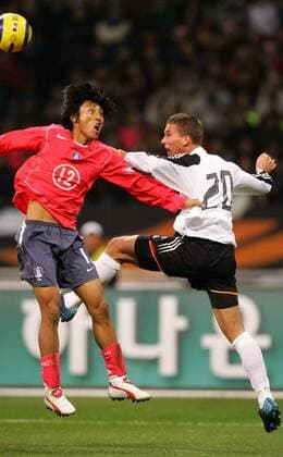 Park Kyu Seon (li., Südkorea) gegen Lukas Podolski (Deutschland) Fußball Länderspiel Herren Länderspiel 2004, Testspiel, Freundschaftsspiel, Test, Asienreise, Asientour, Länderspielreise Gruppe Busan Dynamik, Höhe,